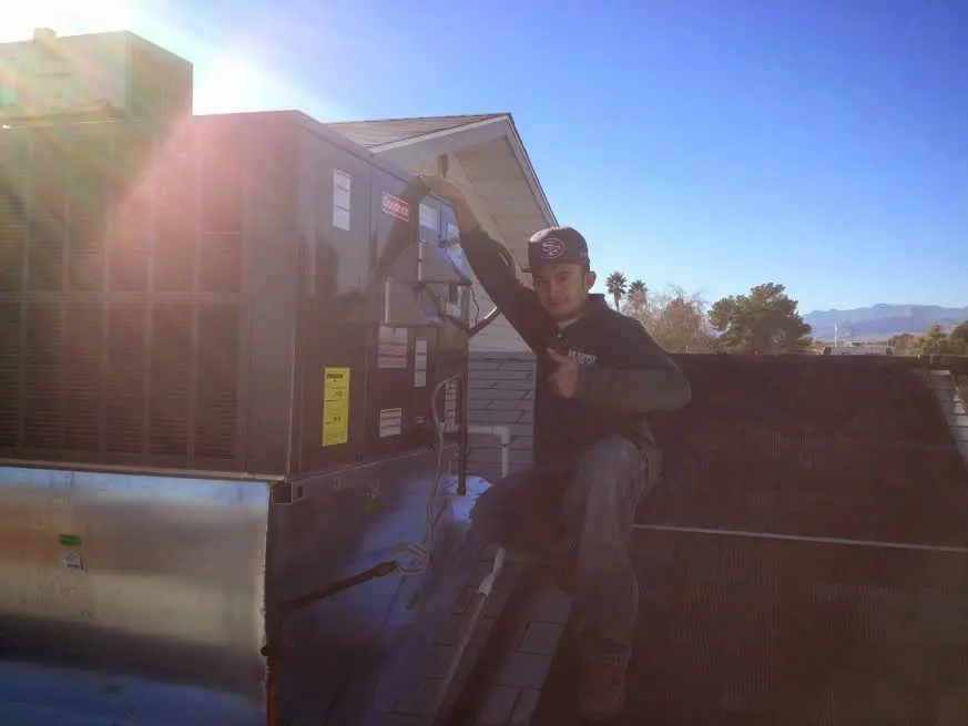 HVAC technician performing Heat Pump Repair on a rooftop unit in Republic