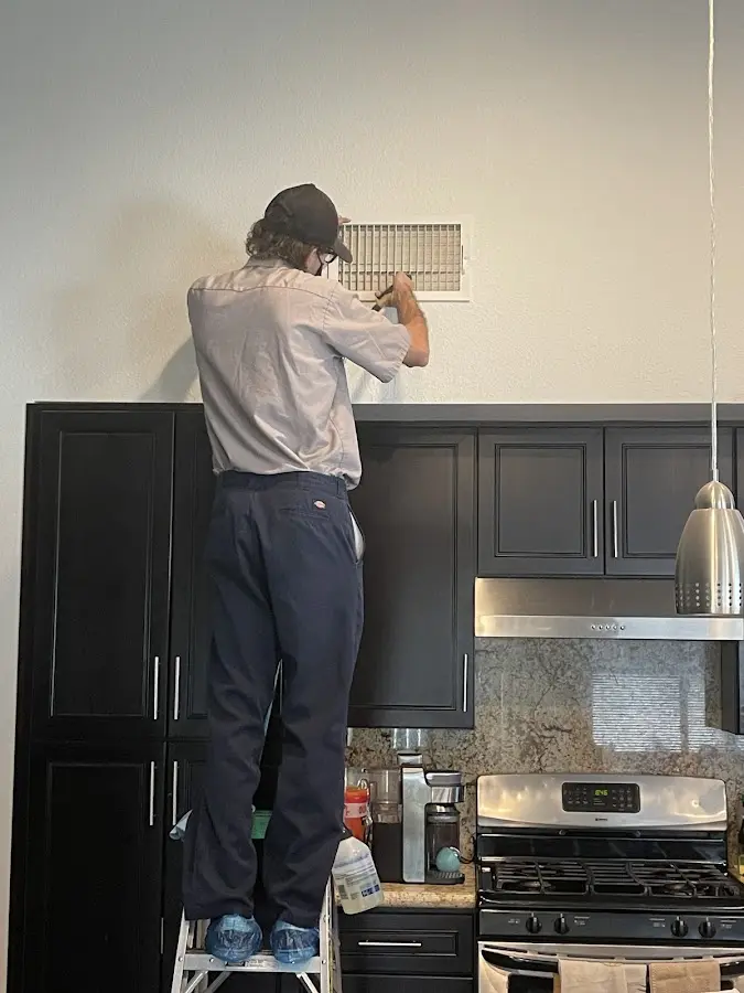 Technician inspecting an air vent during HVAC service in Republic